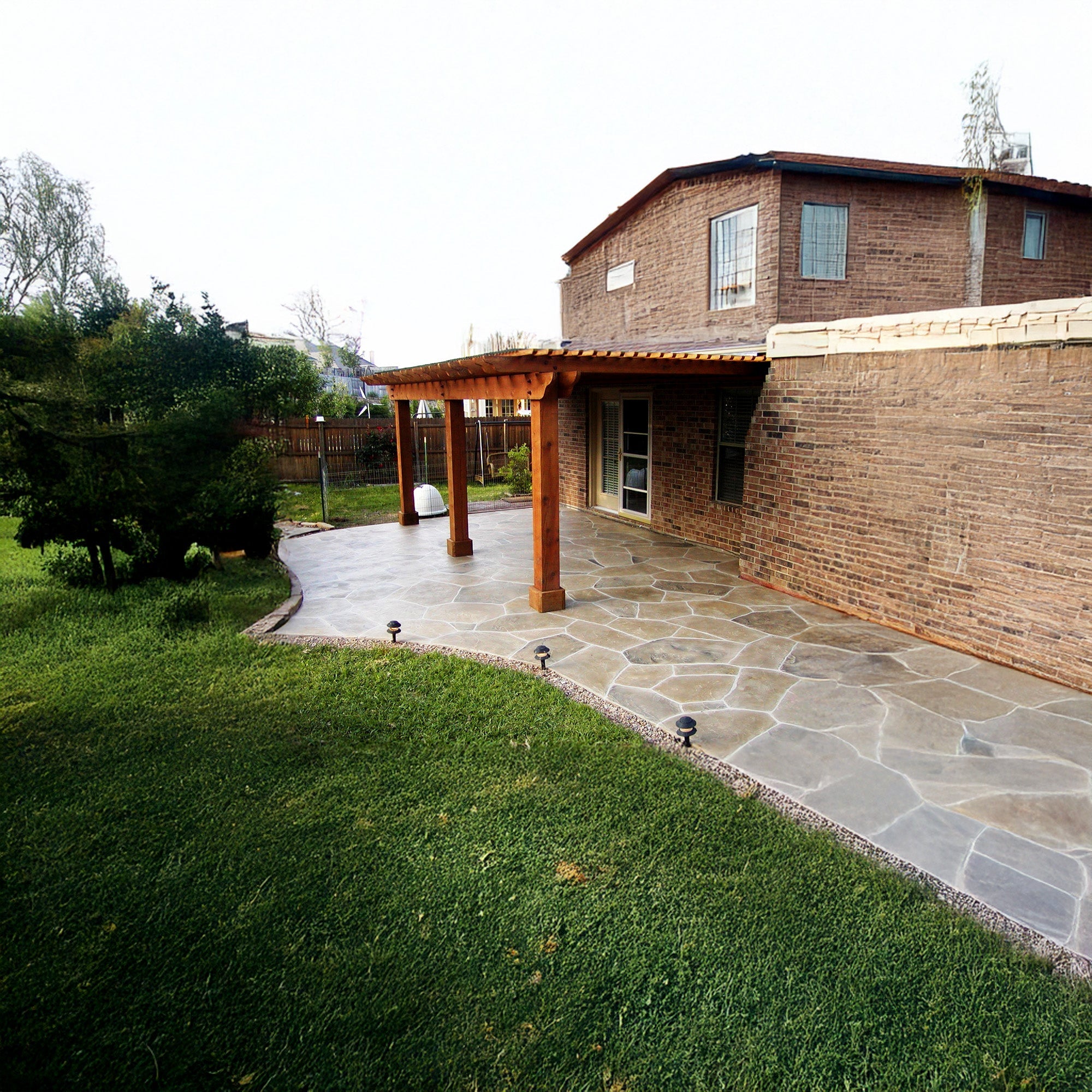 Sealed flagstone patio with a natural, low-sheen finish beside a brick home