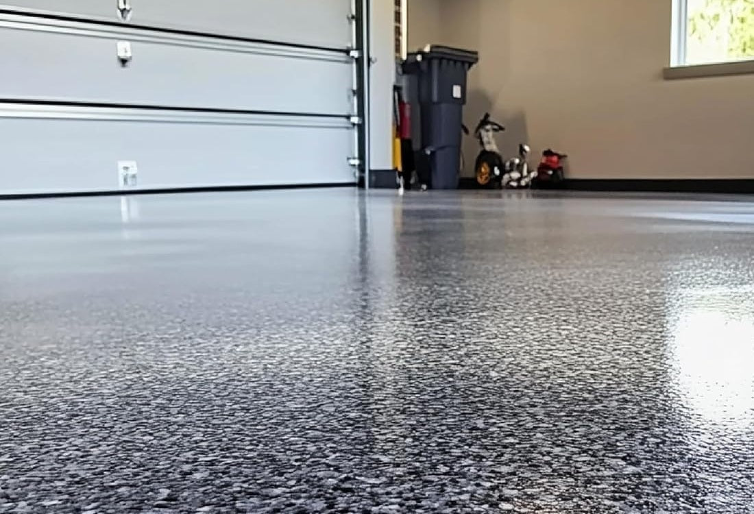 Residential two-car garage with a charcoal and white epoxy flake floor under a high-gloss finish