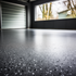 Garage floor with 50% black and white epoxy flake broadcast on a dark gray base. This shows a Matte 2 part Water Based Urethane finish by Mckinnon Materials