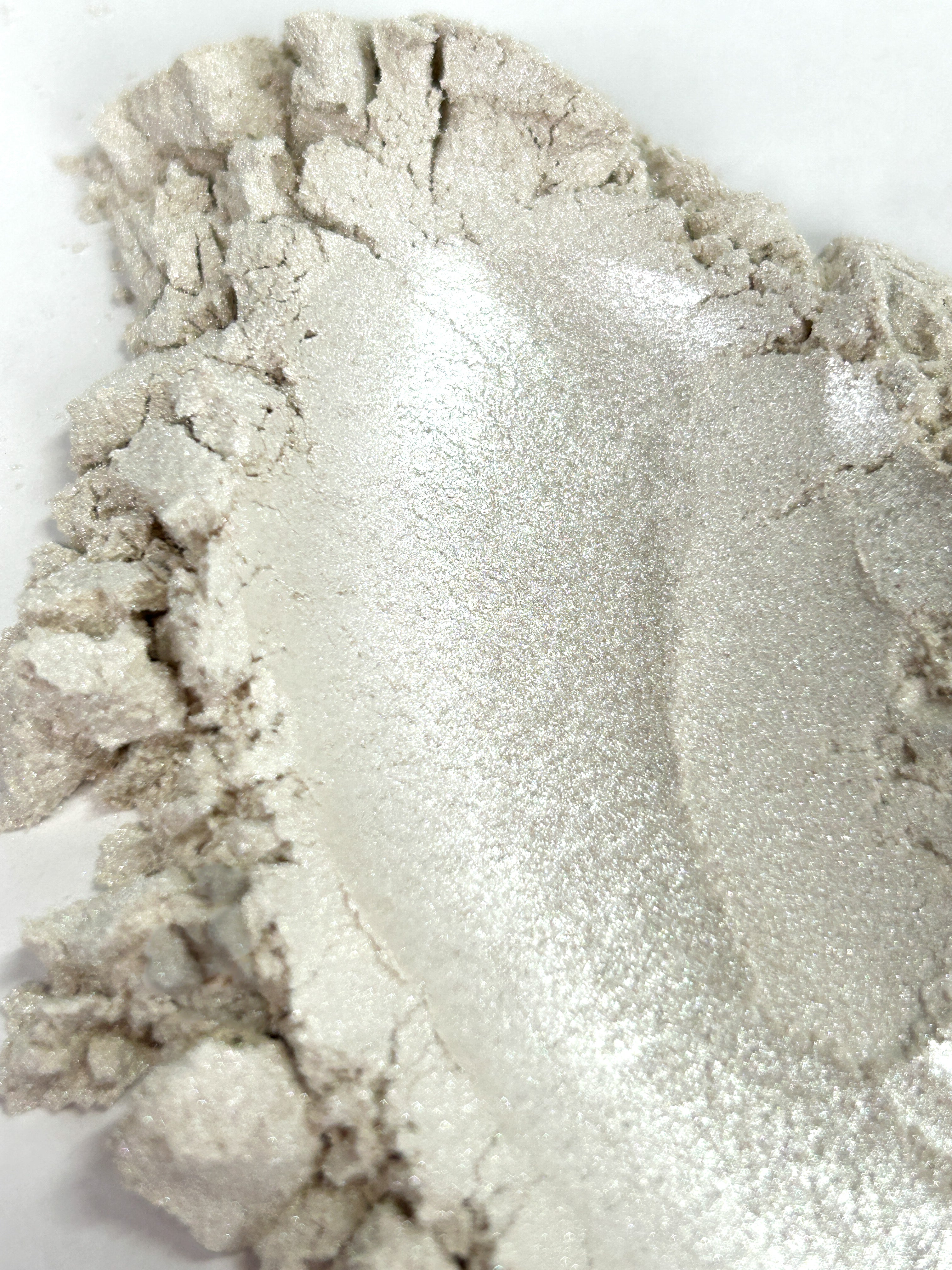 Close-up of silver makeup powder on a white background